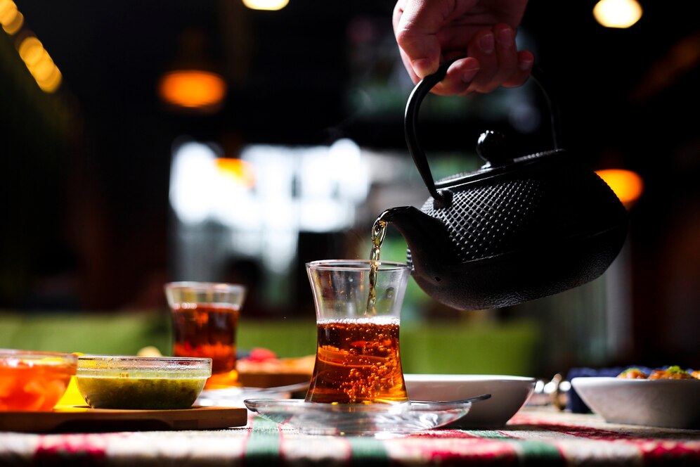 man-pouring-tea-into-armudu-glass-from-stone-teapot_141793-2090.jpg