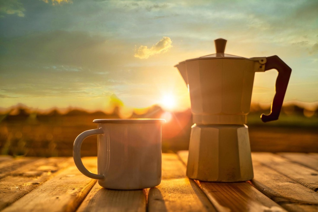 hot-coffee-cup-and-moka-pot-with-sunrise-background-free-photo.jpg