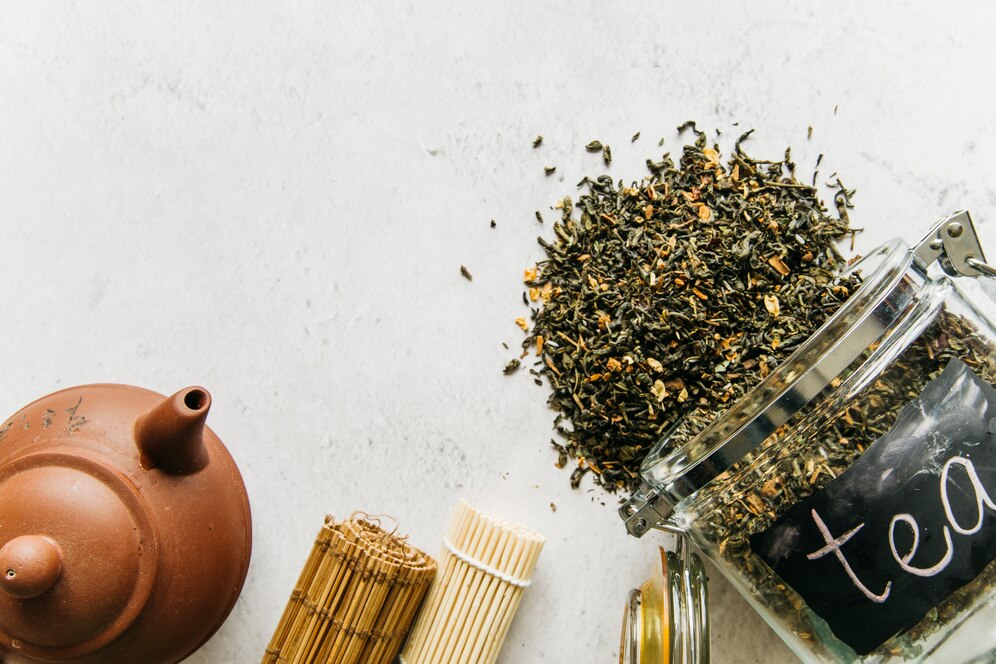 clay-teapot-rolled-up-placemat-with-spilled-dried-herbal-tea-spilled-from-glass-jar_23-2148186317.jpg